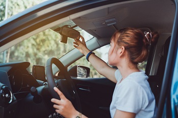 Teen Driver Adjusting Mirror