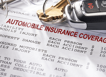 a set of car keys on top of a form that reads automobile insurance coverage