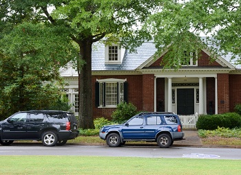 two cars parked in front of a single family home