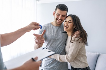 Young Couple Getting Keys To Their First Home